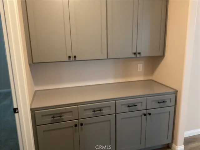 a view of a kitchen from the hallway with wooden floor and a sink