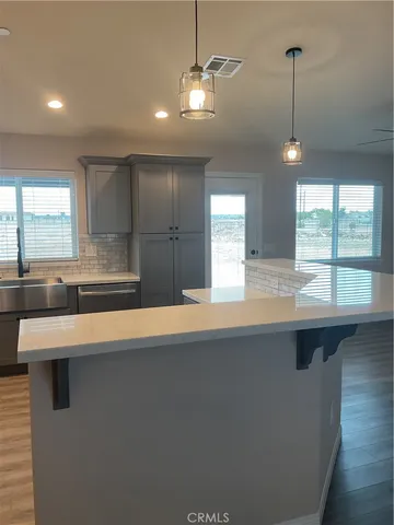 a view of a room with wooden floor and kitchen view