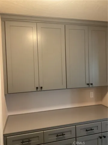 a large kitchen with stainless steel appliances a large counter top a stove a chimney a sink and a window