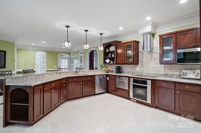 a large kitchen with stainless steel appliances granite countertop a sink and a stove
