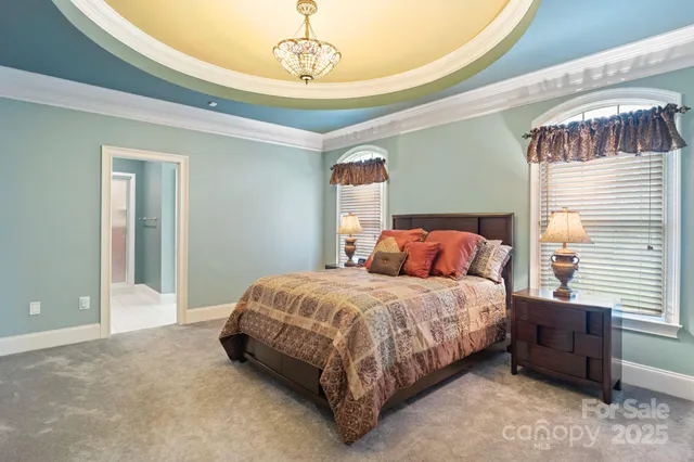 a bedroom with a bed and a chandelier