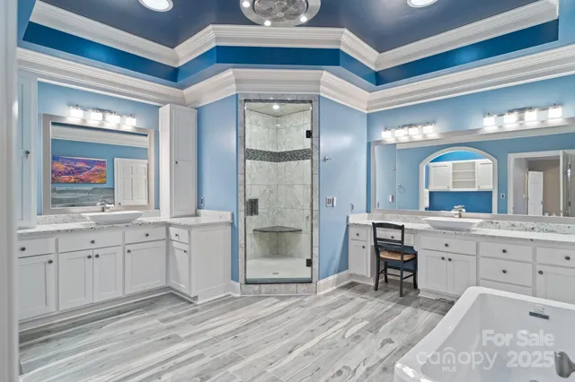 a spacious bathroom with a granite countertop sink mirror and a bathtub