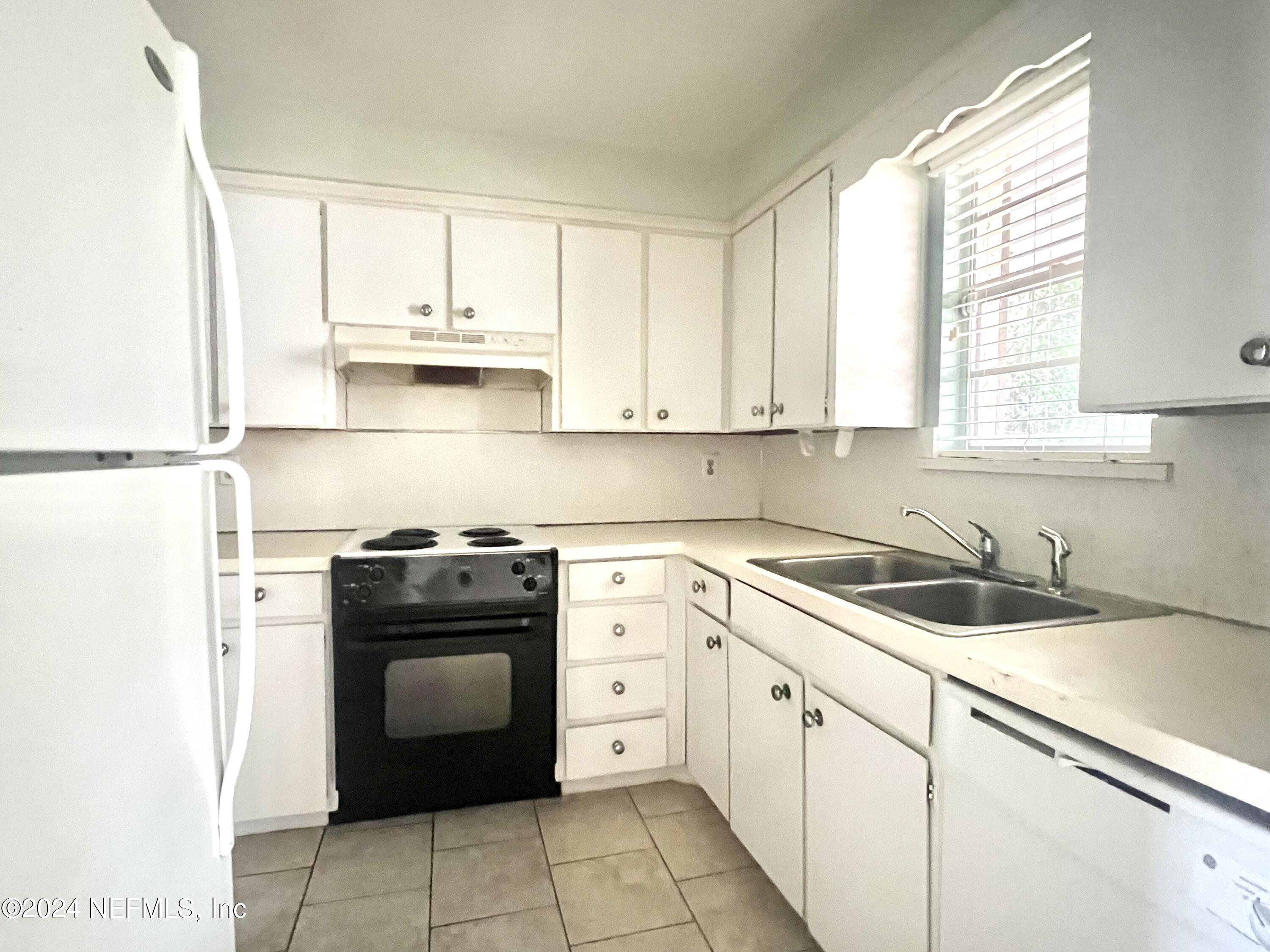 1631 El Prado Road, Unit 4 Jacksonville, FL 32216 - Photo 5 of 23 a kitchen with a stove sink and cabinets