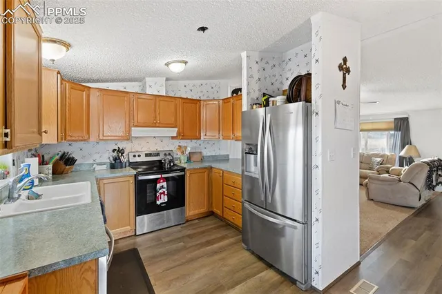 a kitchen with stainless steel appliances granite countertop a refrigerator stove and sink
