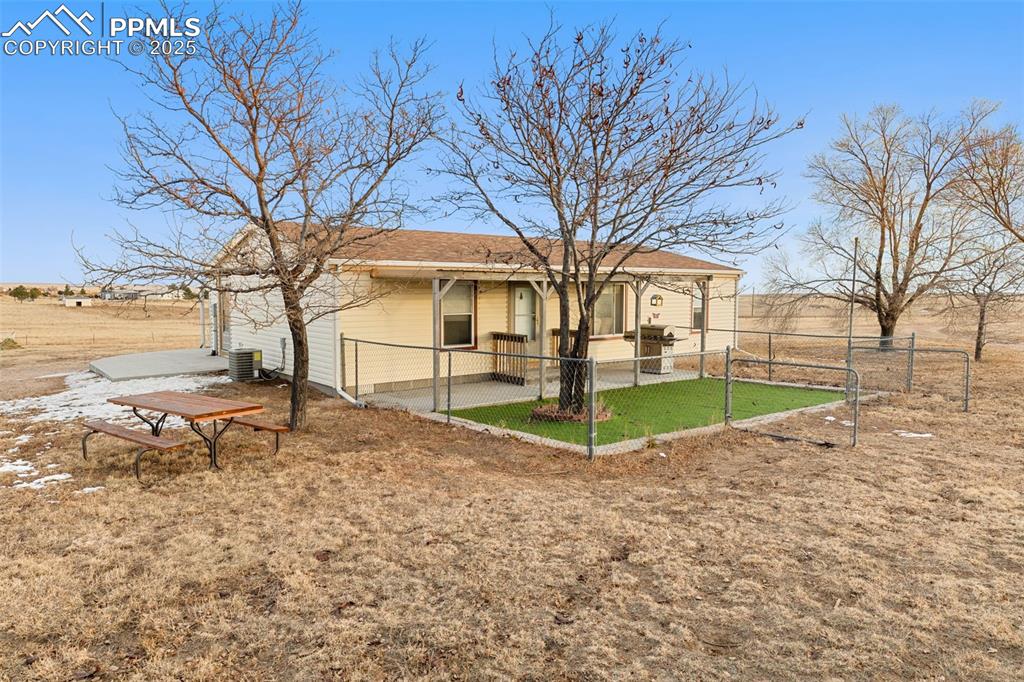 20480 Drennan Road Colorado Springs, CO 80928 - Photo 2 of 47 a view of a white house with a yard and large trees