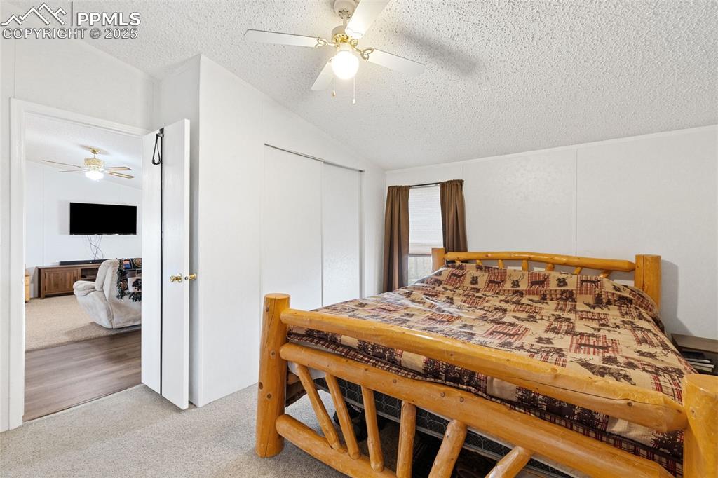 20480 Drennan Road Colorado Springs, CO 80928 - Photo 24 of 47 a bedroom with a large bed and a flat tv screen