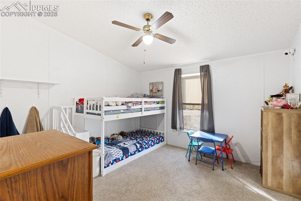 20480 Drennan Road Colorado Springs, CO 80928 - Photo 30 of 47 a living room with a baby crib furniture a chandelier and a table