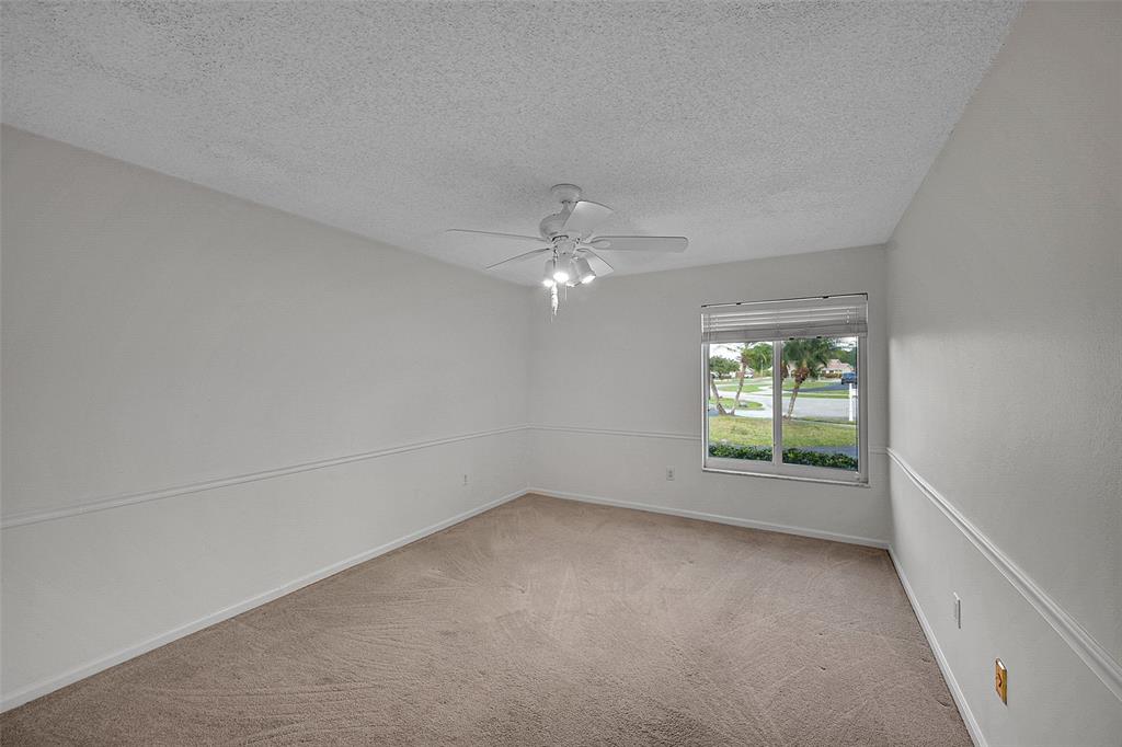 22299 Solitude Drive Boca Raton, FL 33428 - Photo 20 of 31 an empty room with windows and ceiling fan