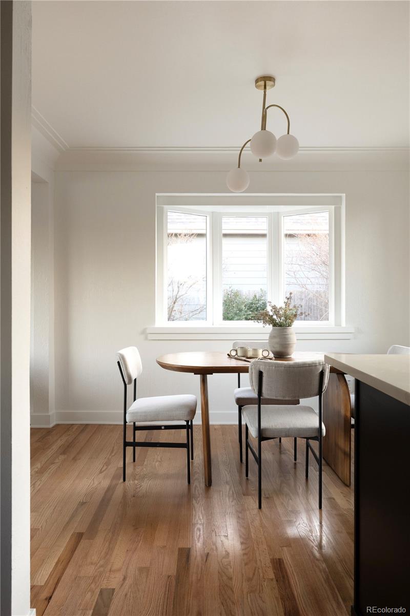1617 Wolff Street Denver, CO 80204 - Photo 16 of 38 a dining room with wooden floor a chandelier a wooden table and chairs