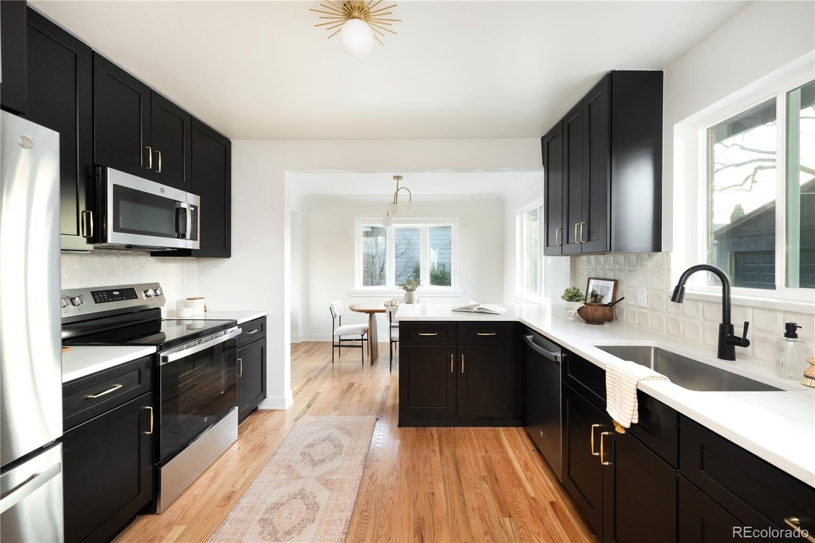 1617 Wolff Street Denver, CO 80204 - Photo 4 of 38 a kitchen with a sink wooden cabinets and stainless steel appliances