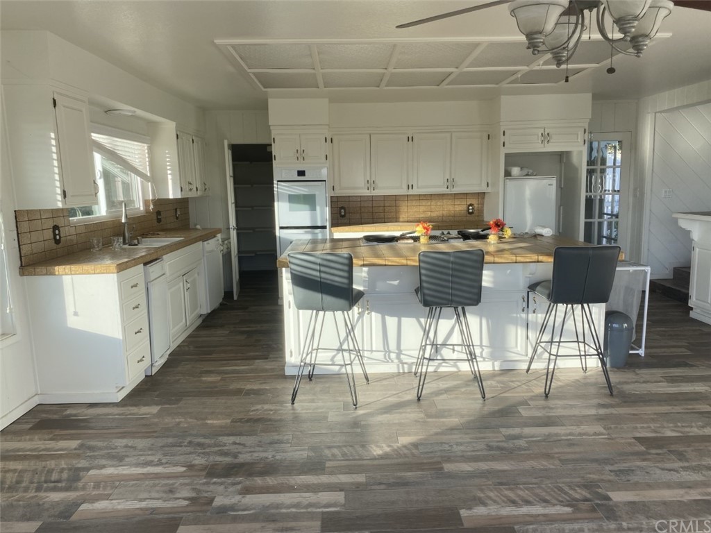 2710 Los Alisos Drive Fallbrook, CA 92028 - Photo 10 of 13 a large kitchen with kitchen island granite countertop lots of white cabinets a sink and stainless steel appliances