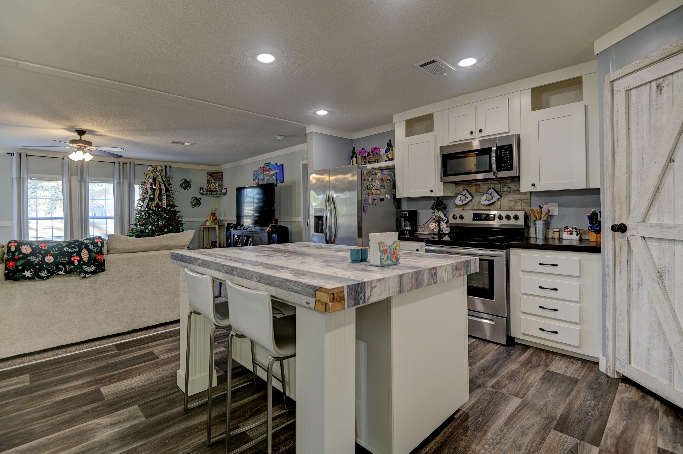 5256 Mt Olive Road Crestview, FL 32539 - Photo 12 of 68 a kitchen with stainless steel appliances a stove a sink dishwasher a refrigerator oven and white cabinets with wooden floor