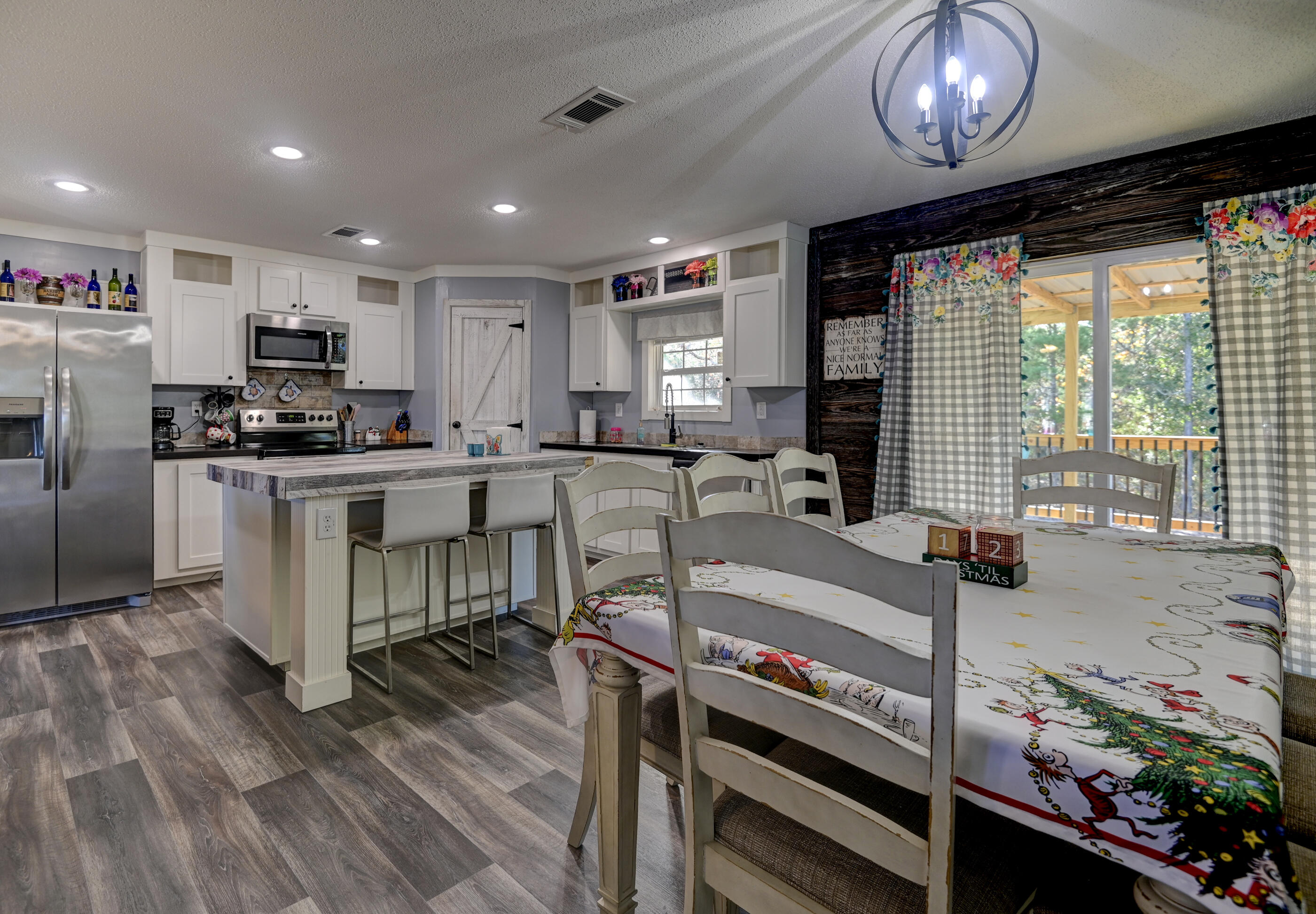 5256 Mt Olive Road Crestview, FL 32539 - Photo 16 of 68 a kitchen with stainless steel appliances granite countertop a stove top oven a sink a dining table and chairs with wooden floor