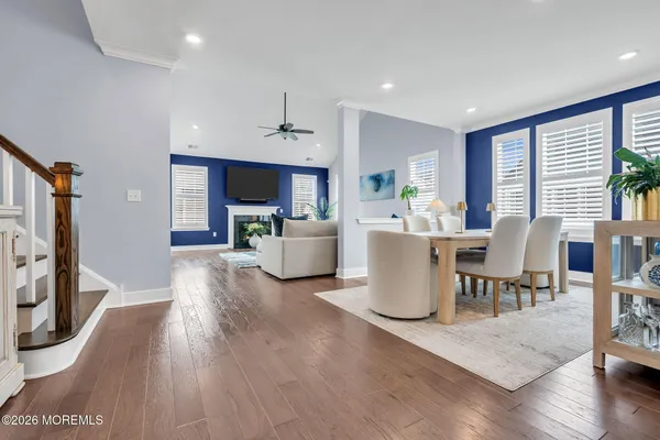 a living room with furniture wooden floor and a kitchen view