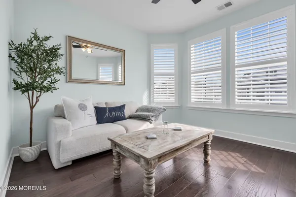 a living room with furniture a flat screen tv and a window