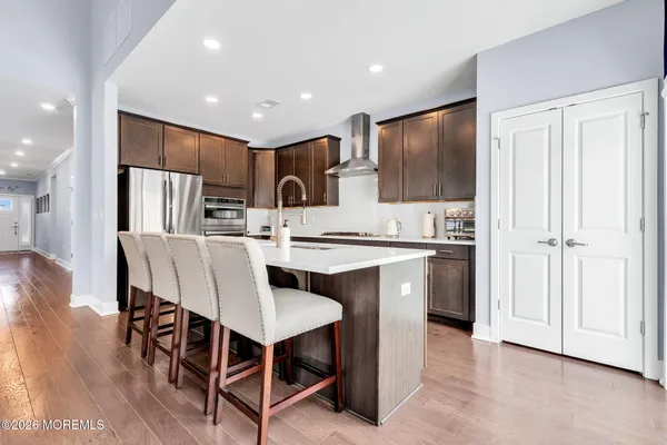 a kitchen with stainless steel appliances granite countertop a sink a stove and refrigerator