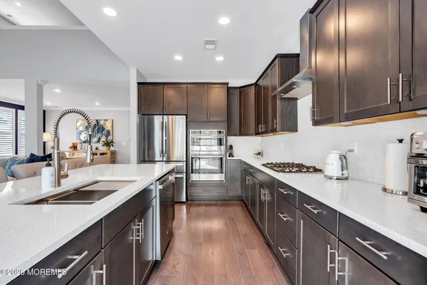 a open kitchen with stainless steel appliances granite countertop a lot of counter space and wooden floors