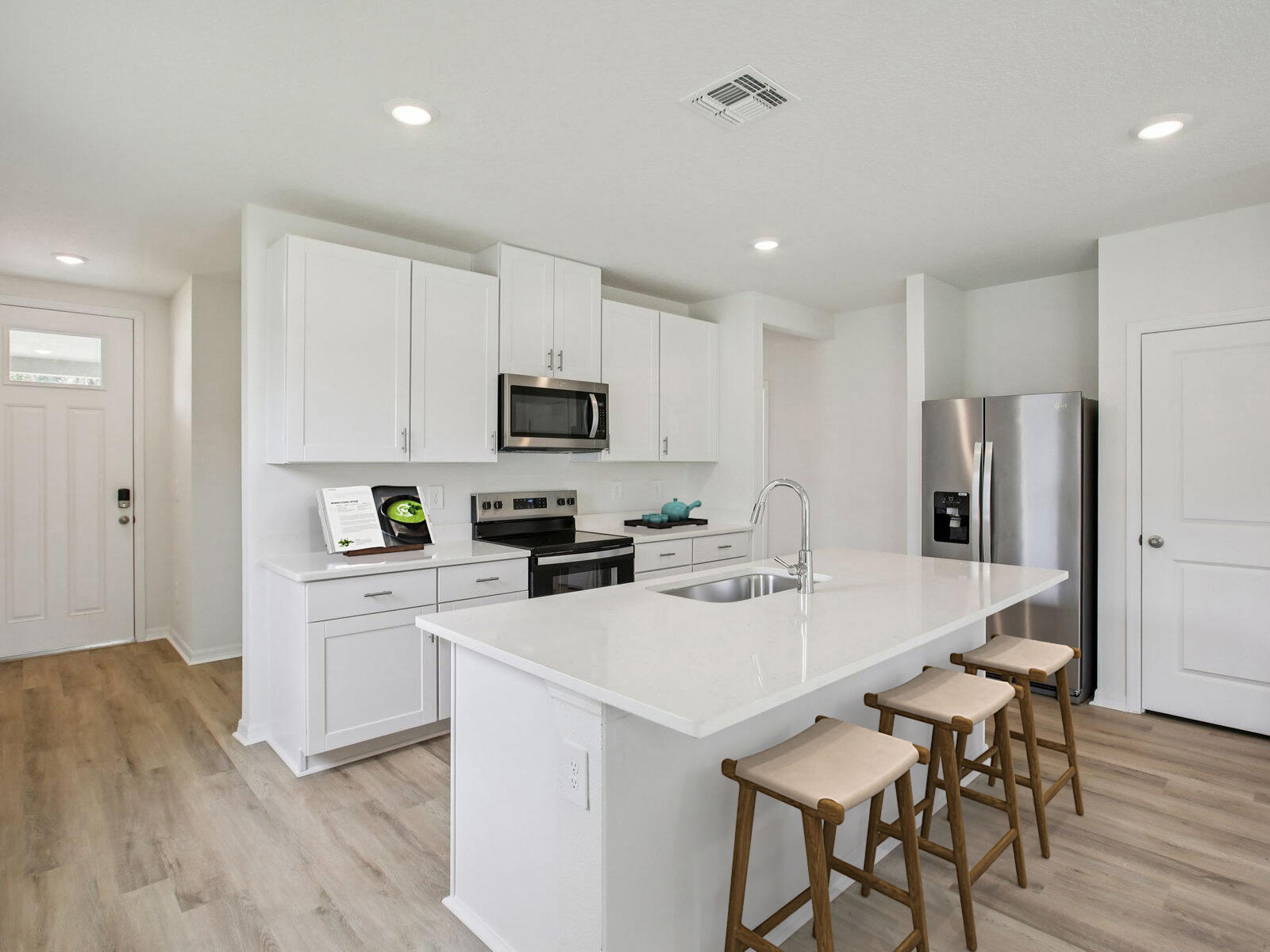 14418 Southwest New Dawn Road Indiantown, FL 34956 - Photo 9 of 16 a kitchen with stainless steel appliances a stove a sink a refrigerator white cabinets and wooden floor