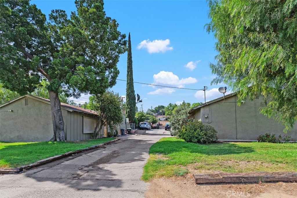 a view of a house with a yard and a large tree