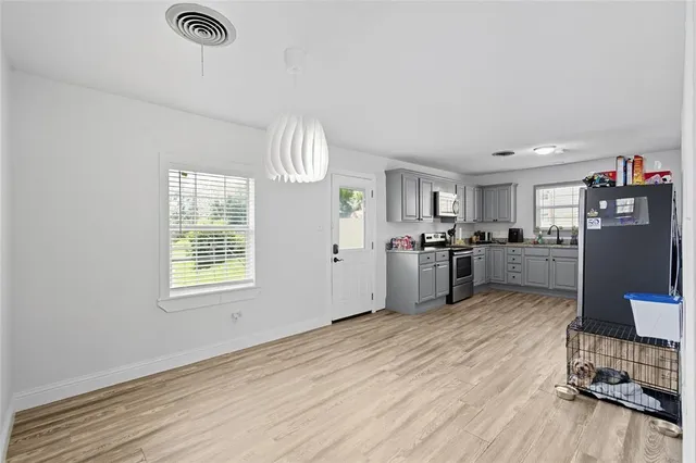 a kitchen with stainless steel appliances granite countertop a refrigerator oven a sink dishwasher and a wooden cabinets with wooden floor