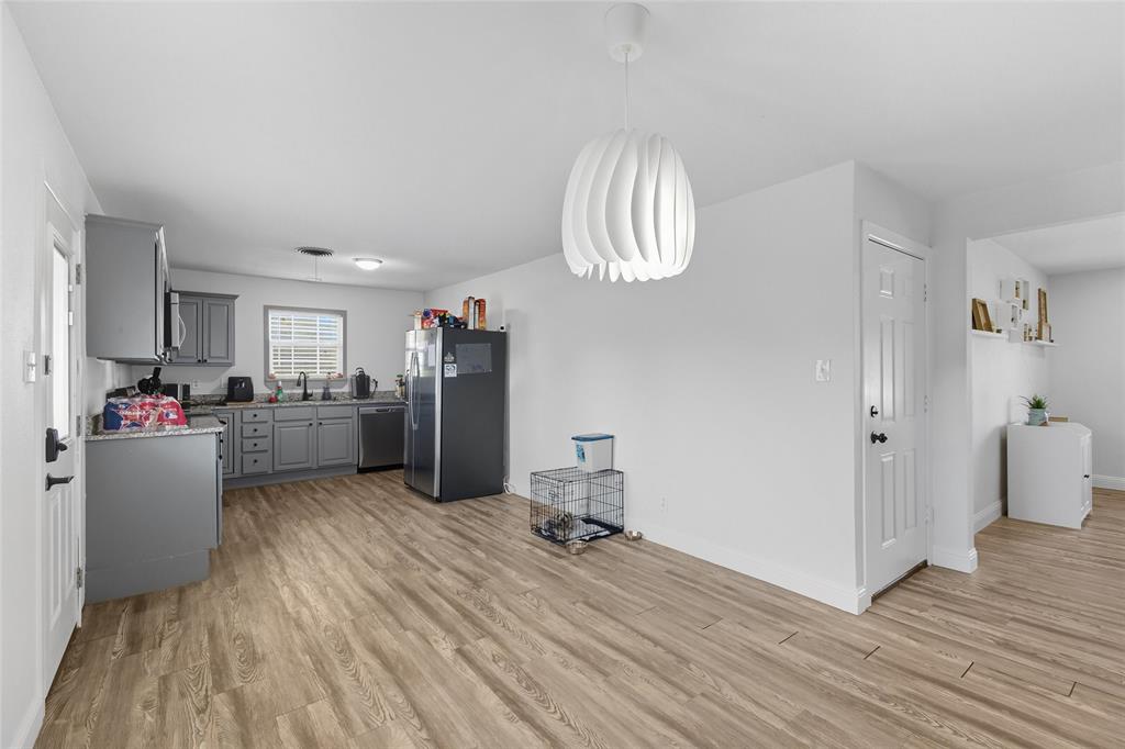 421 East Tarrant Road Grand Prairie, TX 75050 - Photo 17 of 32 Kitchen featuring gray cabinets, pendant lighting, stainless steel appliances, light wood-style flooring, and light countertops