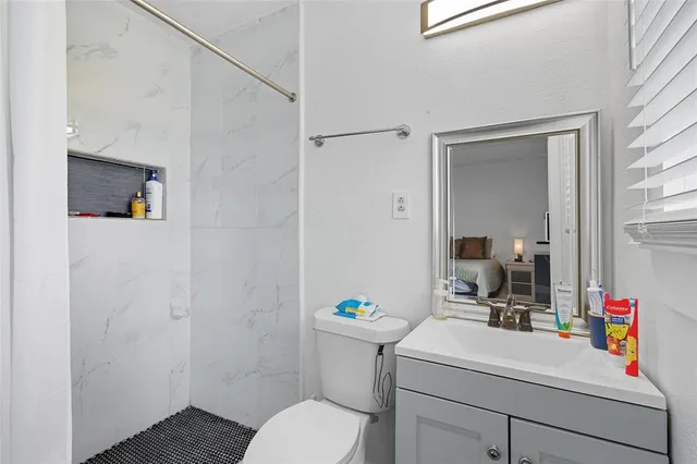 a bathroom with a sink vanity mirror and toilet
