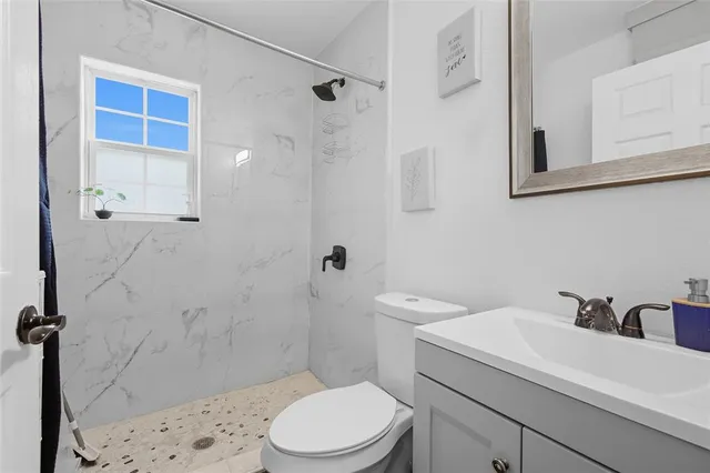 a bathroom with a sink a toilet and shower