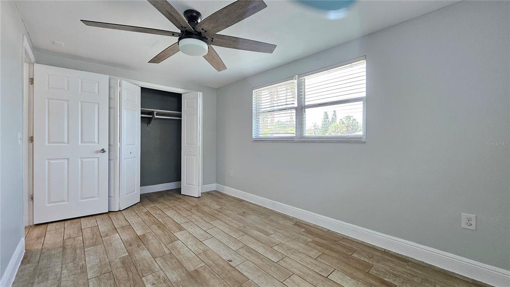 6412 Pawling Avenue Port Richey, FL 34668 - Photo 12 of 24 a view of an empty room with a window and wooden floor