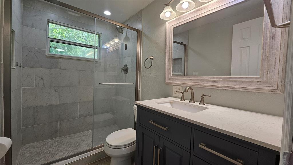 6412 Pawling Avenue Port Richey, FL 34668 - Photo 14 of 24 a bathroom with a sink a toilet and shower
