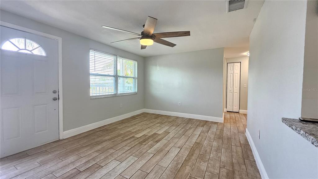 6412 Pawling Avenue Port Richey, FL 34668 - Photo 3 of 24 an empty room with wooden floor fan and windows