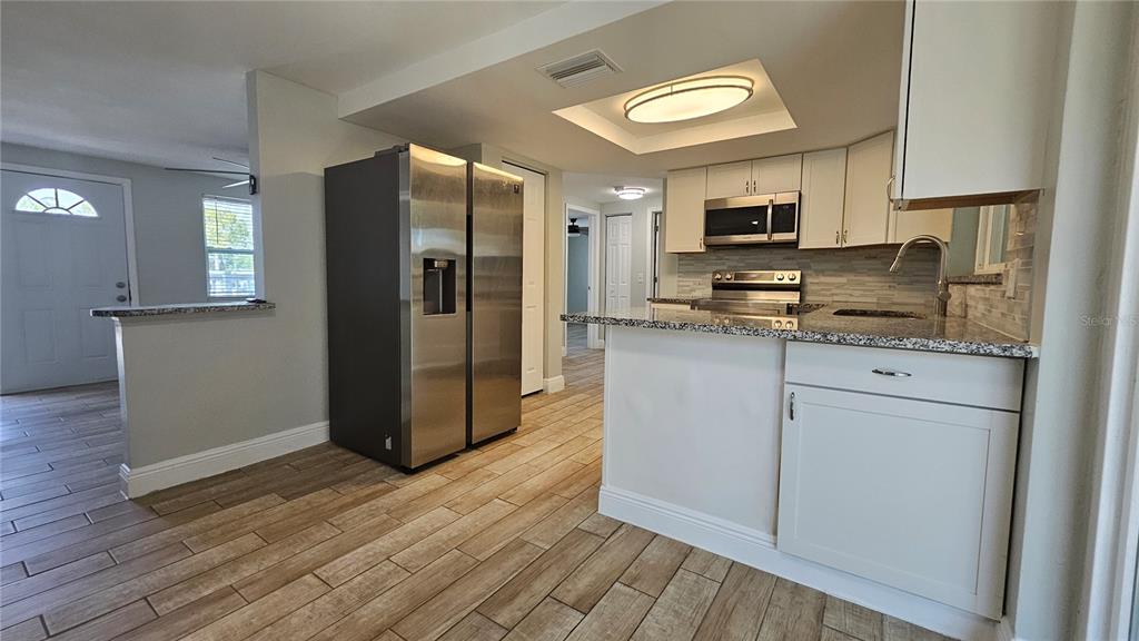 6412 Pawling Avenue Port Richey, FL 34668 - Photo 5 of 24 a kitchen with stainless steel appliances a refrigerator sink and microwave