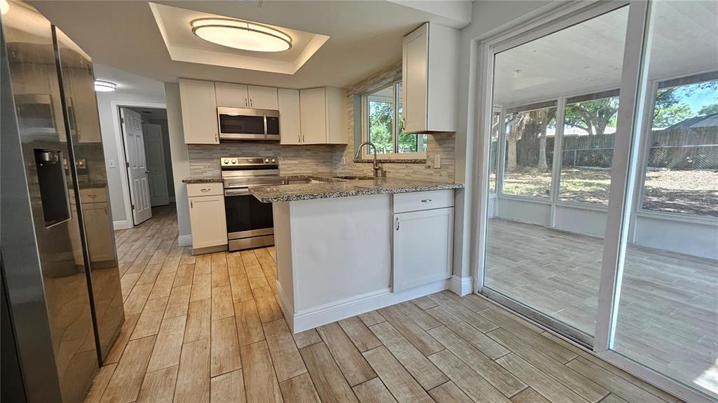 6412 Pawling Avenue Port Richey, FL 34668 - Photo 7 of 24 a kitchen with stainless steel appliances a refrigerator and a stove top oven