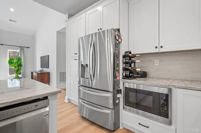 a kitchen with granite countertop white cabinets and stainless steel appliances