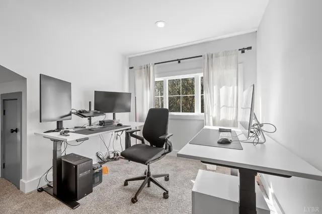 a living room with furniture and large windows