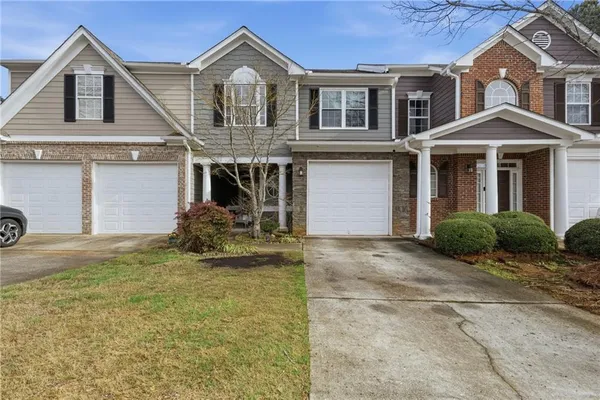 a front view of a house with a yard and garage