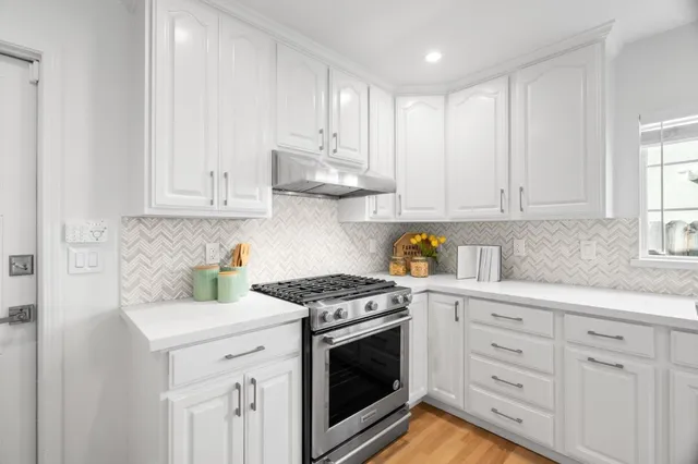 a kitchen with granite countertop white cabinets stainless steel appliances and sink