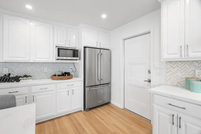a kitchen with cabinets stainless steel appliances and wooden floor
