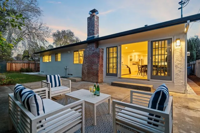 a view of a patio with couches chairs and city view