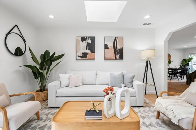 a living room with furniture a couch and potted plant