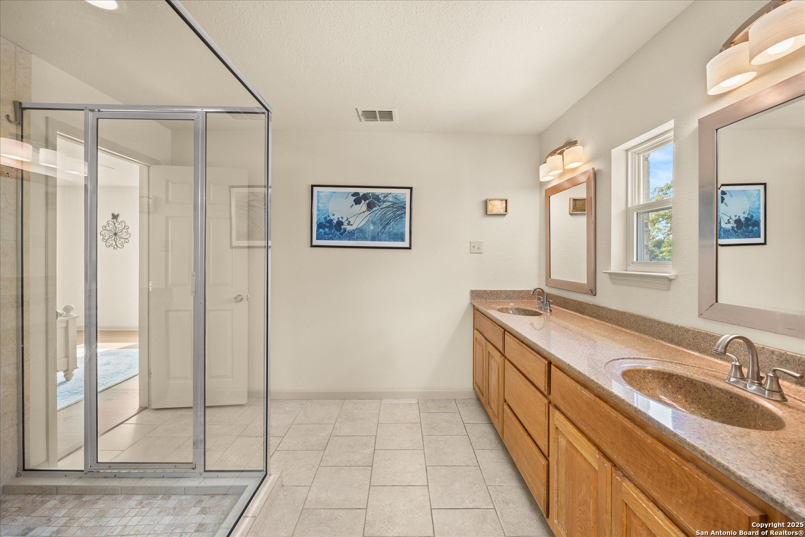 127 Camp Alzafar Road Boerne, TX 78006 - Photo 23 of 50 a bathroom with a granite countertop sink a mirror a and a shower