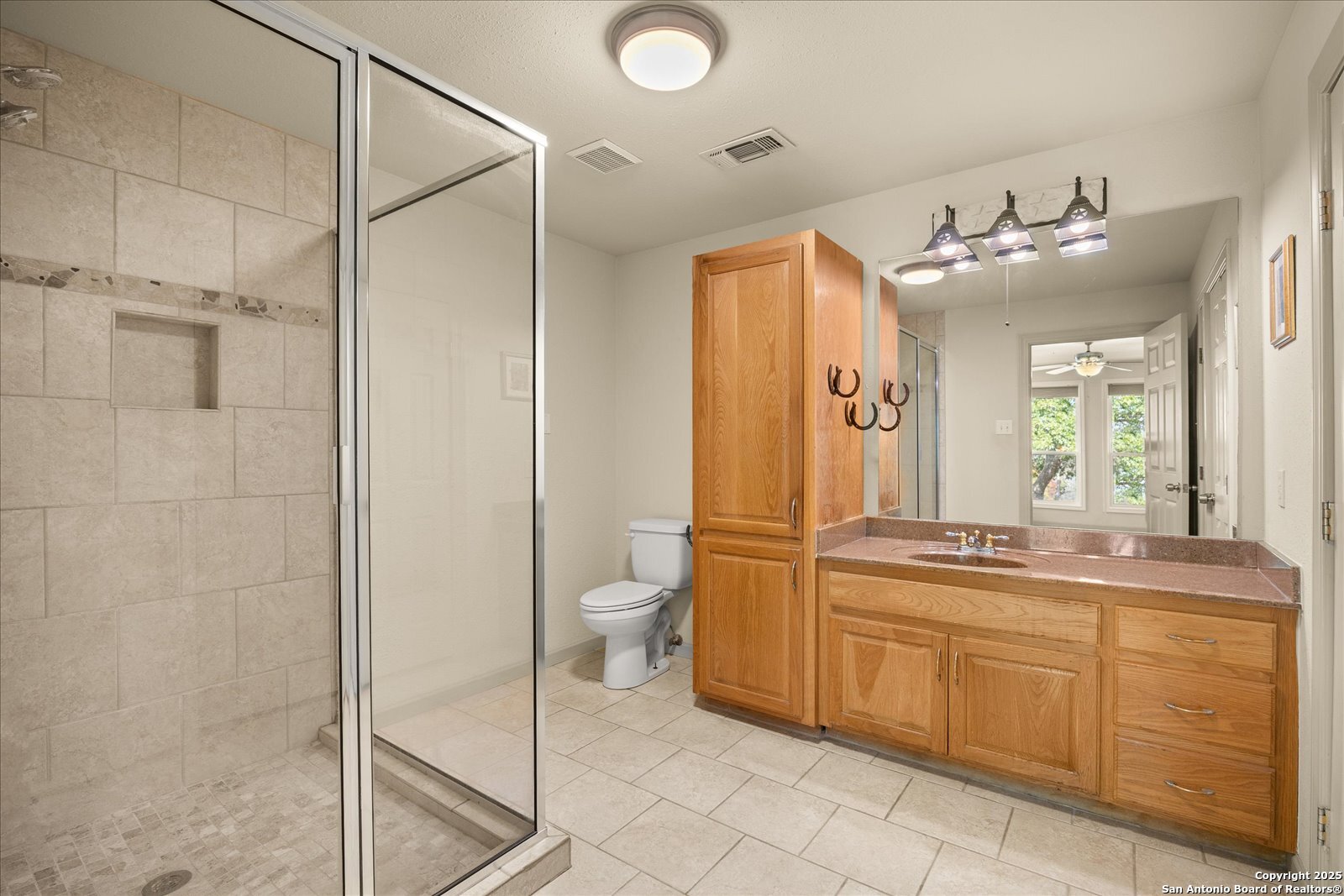 127 Camp Alzafar Road Boerne, TX 78006 - Photo 26 of 50 a bathroom with a double vanity sink mirror and toilet