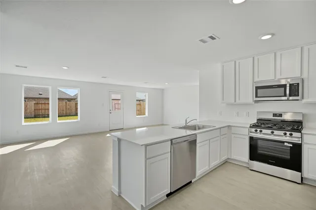 a kitchen with stainless steel appliances granite countertop a sink stove and cabinets