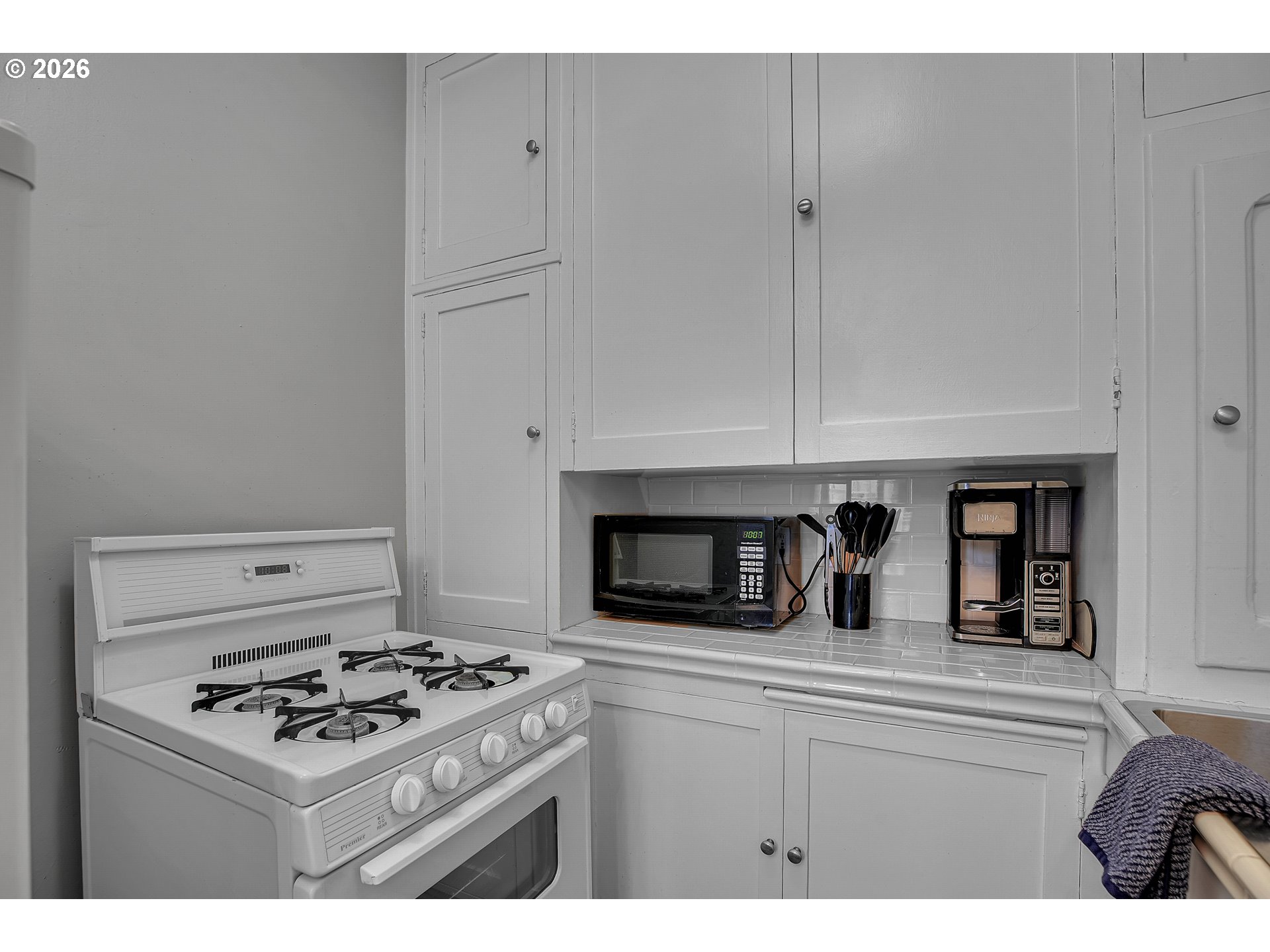 709 Southwest 16th Avenue, Unit 207 Portland, OR 97205 - Photo 31 of 47 a kitchen with white cabinets and appliances