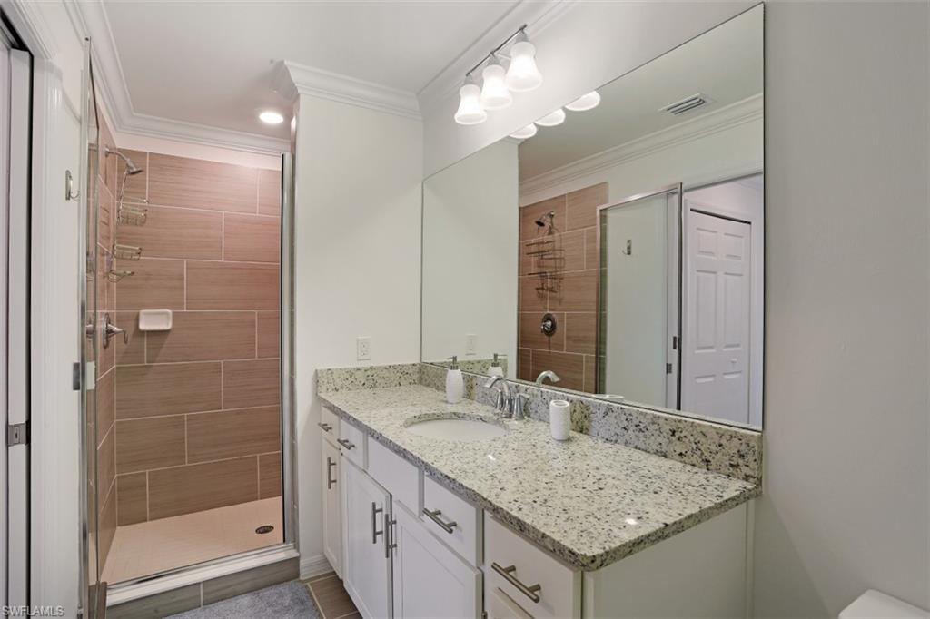 43010 Greenway Boulevard, Unit 234 Punta Gorda, FL 33982 - Photo 12 of 22 a bathroom with a granite countertop sink a mirror and a shower