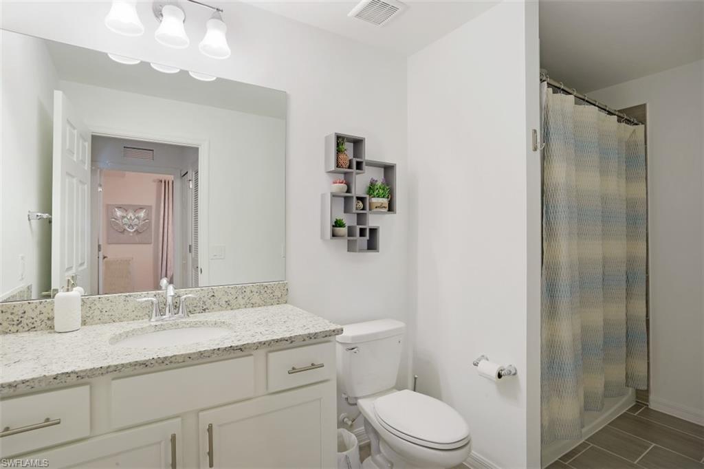 43010 Greenway Boulevard, Unit 234 Punta Gorda, FL 33982 - Photo 14 of 22 a bathroom with a granite countertop sink toilet a mirror a vanity and shower