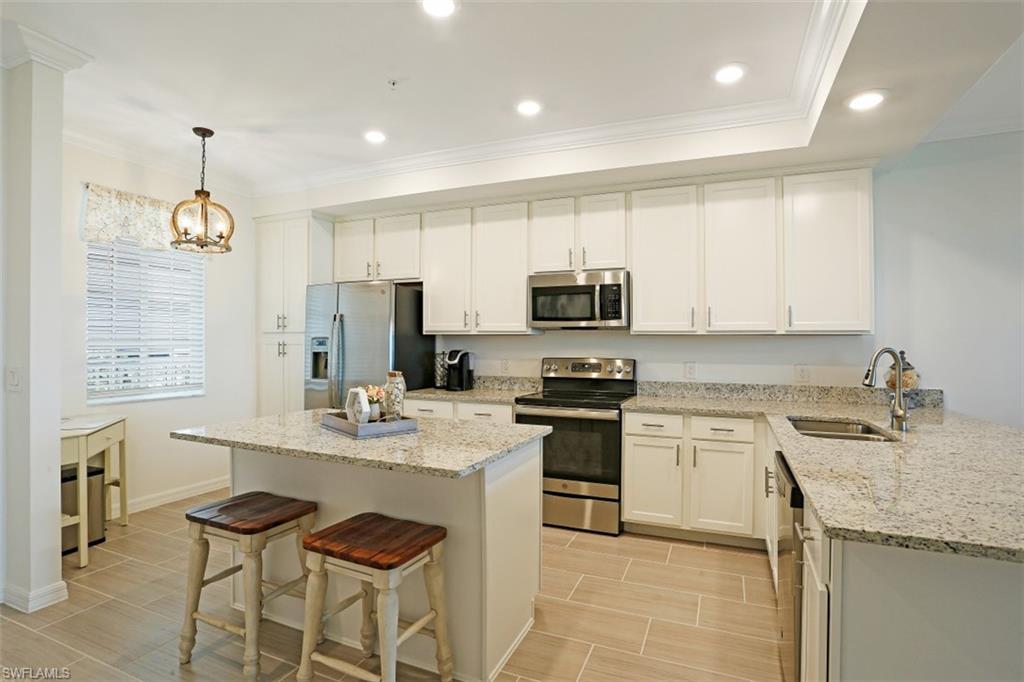 43010 Greenway Boulevard, Unit 234 Punta Gorda, FL 33982 - Photo 5 of 22 a kitchen with stainless steel appliances granite countertop a sink a stove a refrigerator cabinets and chairs