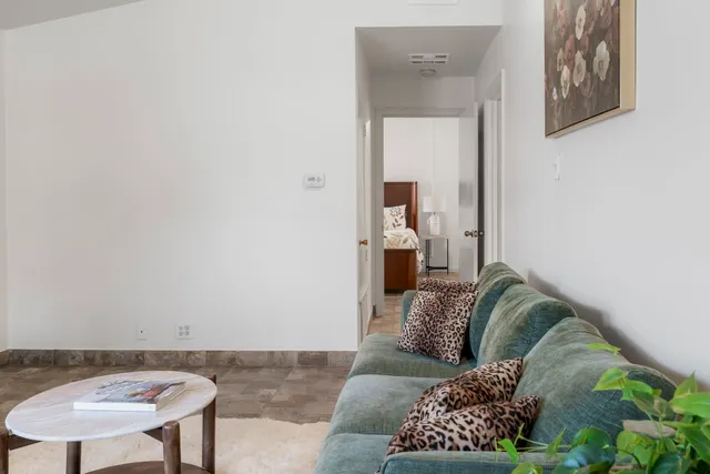 a bed sitting in a bedroom next to a window and a chandelier