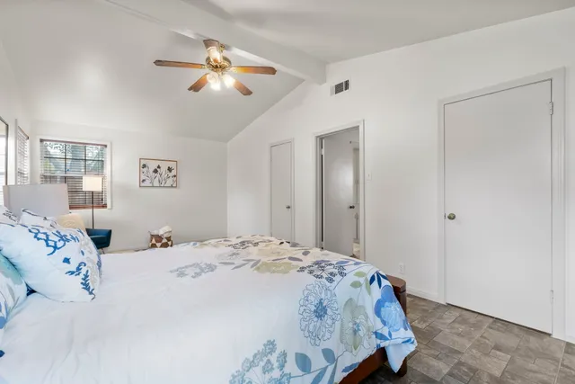 a bedroom with a large bed and a chandelier