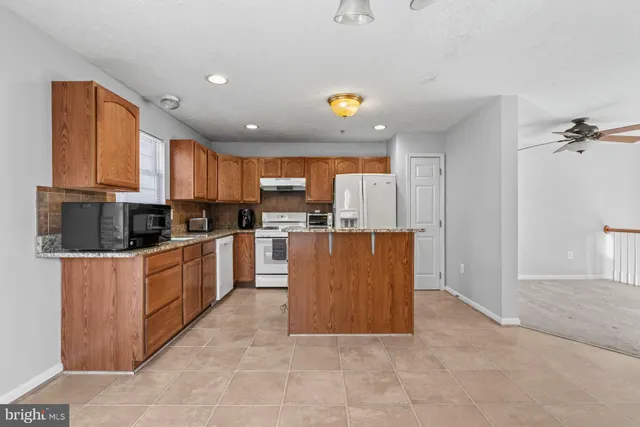 a kitchen with stainless steel appliances granite countertop a stove top oven a refrigerator a sink and dishwasher