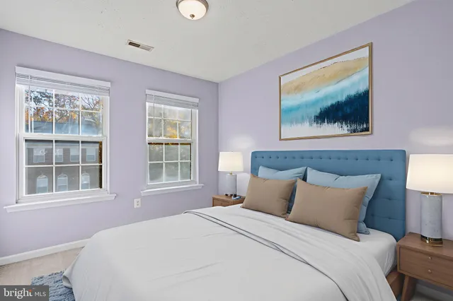 a bedroom with a bed and a painting on the wall